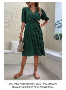 Detail view of dark green pleated v-neck summer dress with waist tie and fluid texture
