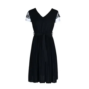 Detail of V-neck black dress with lace sleeve trim and pleated skirt texture