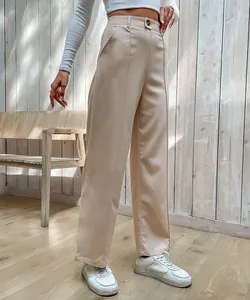 Détail d'un pantalon large beige à taille haute avec fermeture boutonnée et plis marqués