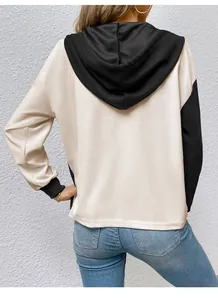 Vista posteriore di una felpa con cappuccio in maglia a nido d'ape beige e nera da donna