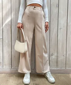 Détail du pantalon beige à taille haute et jambe large avec couture avant et bouton brun