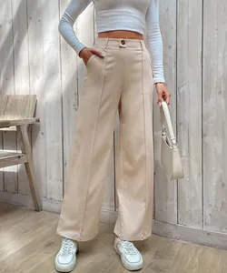 Détail du pantalon beige à taille haute avec plis centraux et fermeture à bouton