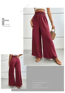Zoom sur la taille haute smockée et la texture du tissu de ce pantalon large bordeaux