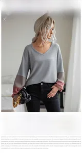 Close-up of v-neck knit sweater featuring waffle texture and color block sleeve detail