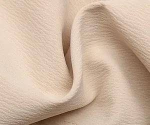 Gros plan sur un tissu beige texturé avec armure horizontale et effet froissé doux