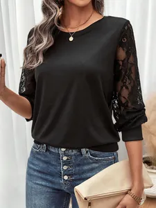 Detailed close-up of semi-transparent lace sleeves on a black crewneck top