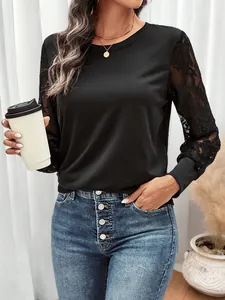 Detailed close-up of delicate black lace patchwork sleeves on a casual sweatshirt