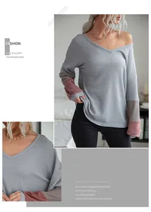 Detail of V-neck waffle knit sweater with contrast patchwork long sleeves in grey