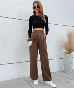 Détail du pantalon taille haute à jambes larges avec plis verticaux et boutons ambre