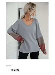 Detail showing waffle knit texture and three-tone color block sleeves on V-neck top