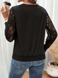 Detail of elegant black sweatshirt featuring delicate lace patchwork on the long sleeves
