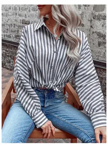 Close-up of gray striped shirt with lapel collar, buttoned cuffs and stylish knot hem