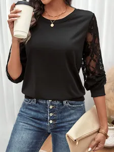 Detail of elegant black long sleeve top featuring floral lace sleeves and ribbed cuffs