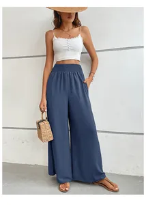 Détail du pantalon à taille haute smockée et jambes larges en tissu bleu marine texturé