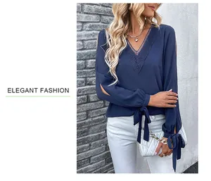Detail der dunkelblauen V-Ausschnitt Bluse mit Spitzenstickerei und Bindedetails am Ärmel