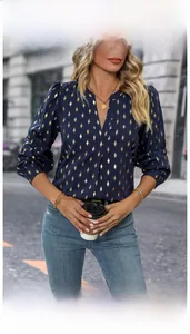 Detail of V-neck long sleeve blouse with gold geometric pattern on navy blue fabric