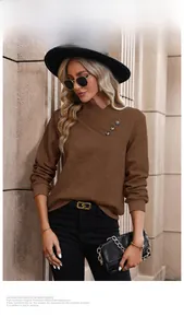 Detail of dark brown long sleeve top with textured fabric and V-neck metal button accents