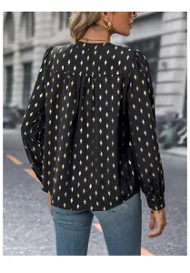 Detail view of women's long sleeve shirt with gold diamond pattern and back pleat design