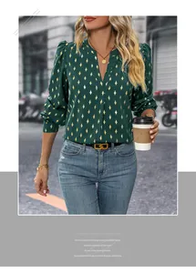 Detail of dark green V-neck blouse with golden diamond print and subtle pleated texture