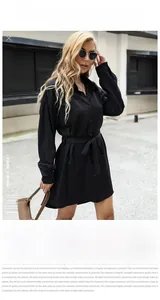 Détail d'une robe chemise noire à manches longues avec col à revers et lien à la taille