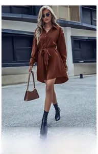 Détail d'une robe chemise en satin marron avec manches longues et ceinture assortie