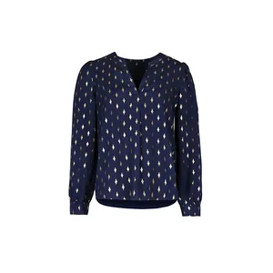 Detail of navy blue V-neck blouse with gold foil diamond patterns and elegant puff sleeves