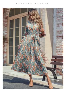 Détail d'une robe maxi plissée fleurie avec col montant et ceinture à nouer en vert clair