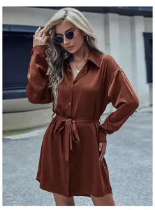 Détail de la robe chemise en satin caramel avec col à revers et ceinture nouée à la taille
