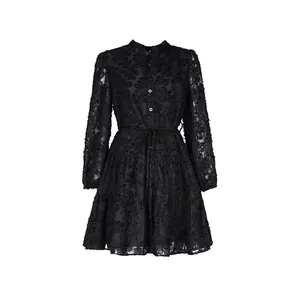 Détail d'une robe noire à manches longues avec texture jacquard florale et boutons blancs