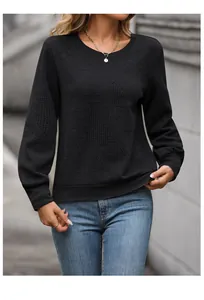 Detail shot of black long-sleeve sweatshirt showing premium textured herringbone knit fabric