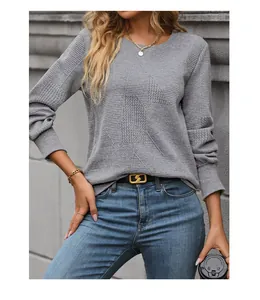 Detailed view of grey long sleeve top featuring unique 3D geometric knit texture and fabric