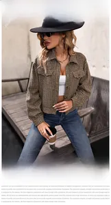 Detail of cropped houndstooth jacket featuring classic collar and buttoned chest pockets