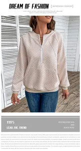 Detail of waffle knit texture on apricot quarter-zip hooded sweatshirt with front pocket