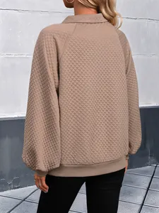 Détail de la texture matelassée en losanges et des poignets côtelés de la veste kaki