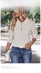 Outdoor street shot of cream knit polo top with textured waffle fabric and button collar
