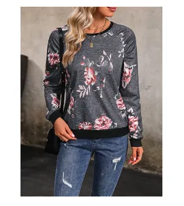 Detail eines grauen Sweatshirts mit Blumenmuster, Rippbündchen und Raglanärmel-Design