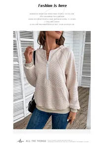 Detail of waffle quilted texture on beige half-zip hoodie with ribbed cuffs