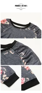 Detail des Blumendrucks auf grauem Sweatshirt mit schwarzem Rippkragen und Raglanärmeln