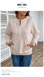 Detail of waffle-textured hoodie with ring zipper and ribbed cuffs in beige color