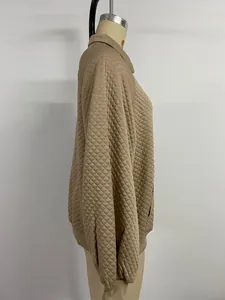 Gros plan détaillé sur la texture matelassée kaki et le col chemise du vêtement