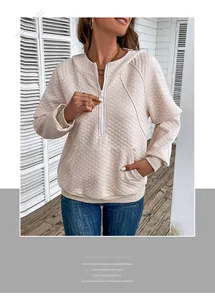 Detail of pink waffle knit hoodie featuring half-zipper, diamond quilting and kangaroo pocket