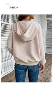 Detail view of waffle knit diamond texture on the back of a beige hooded sweatshirt