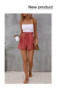 Chic high-waisted paperbag shorts in terracotta with matching fabric belt and metal eyelets