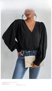 Close-up of elegant black V-neck wrap bodysuit with puff sleeves and textured details