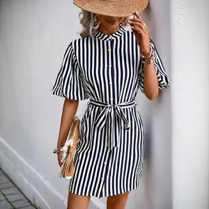 Détail de la robe chemise rayée bleu et blanc avec fermeture boutonnée et ceinture nouée
