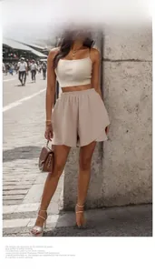 Detail showing beige textured fabric of high waisted loose shorts and matching crop top set