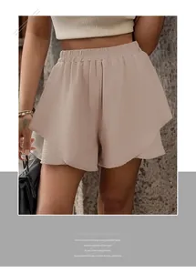 Detail of high waisted tiered shorts with crinkle texture in apricot beige fabric