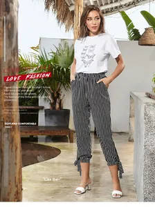 Detail of white cotton butterfly t-shirt paired with striped bow-tie pants set
