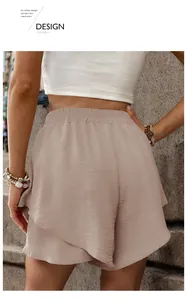 Detail view of high-waisted beige shorts with elastic waistband and layered ruffles