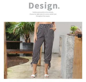 Detail view of high waist vertical stripe pants with stylish ankle tie bow accents